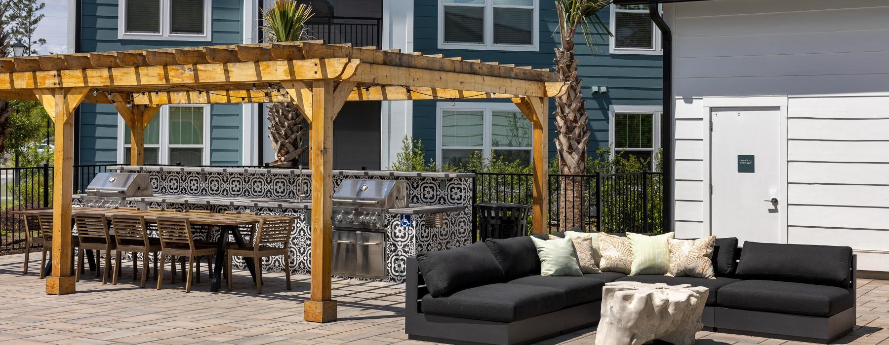 a patio with a table and chairs and a couch in front of an apartment